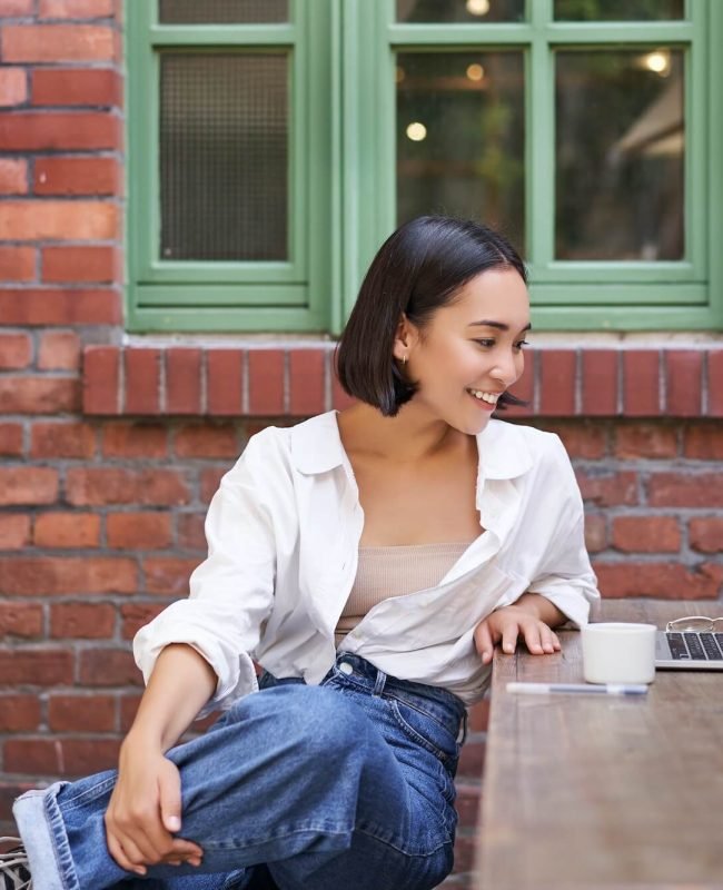 portrait-of-young-stylish-woman-influencer-sitting-in-cafe-with-cup-of-coffee-and-laptop-smiling.jpg